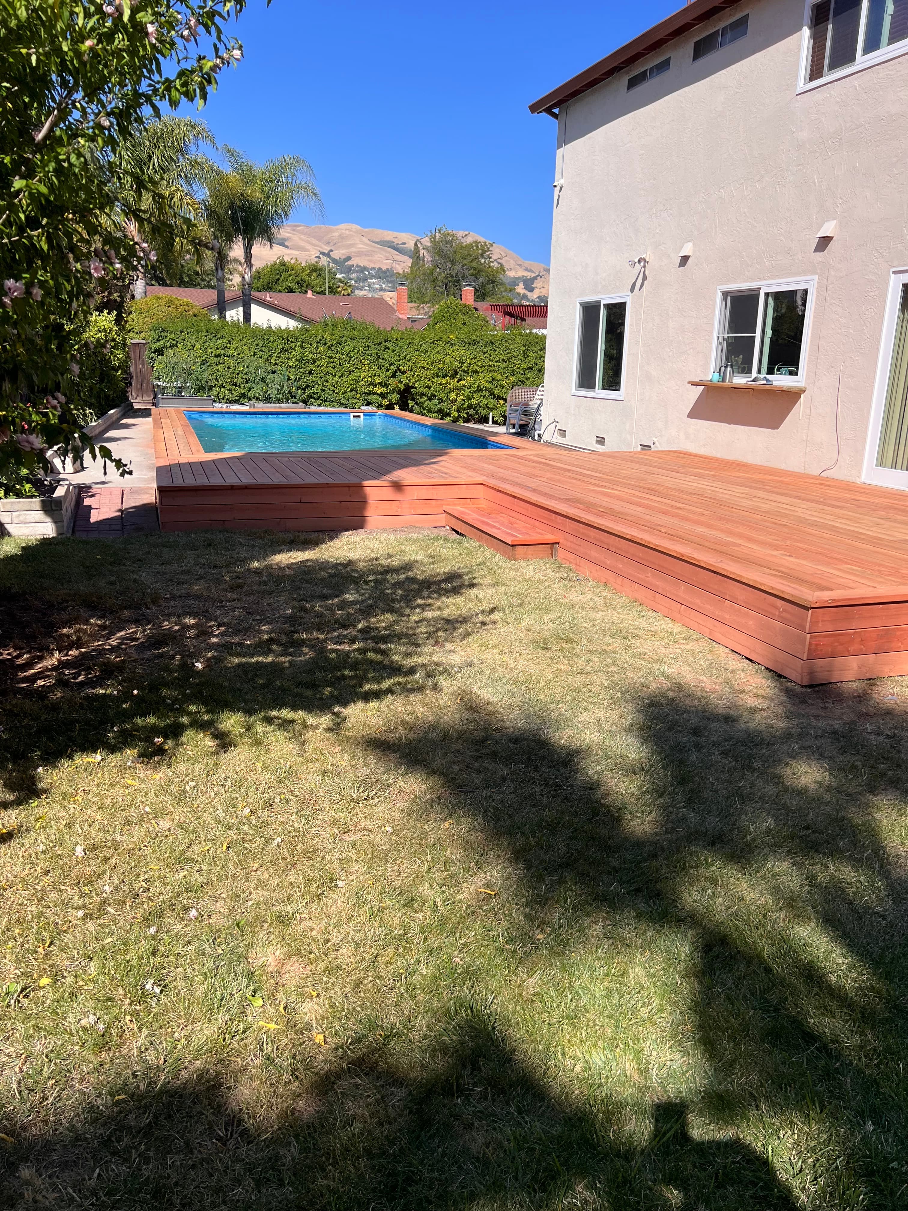 Finished redwood pool deck with lush Bay Area backyard built by Far West Builders