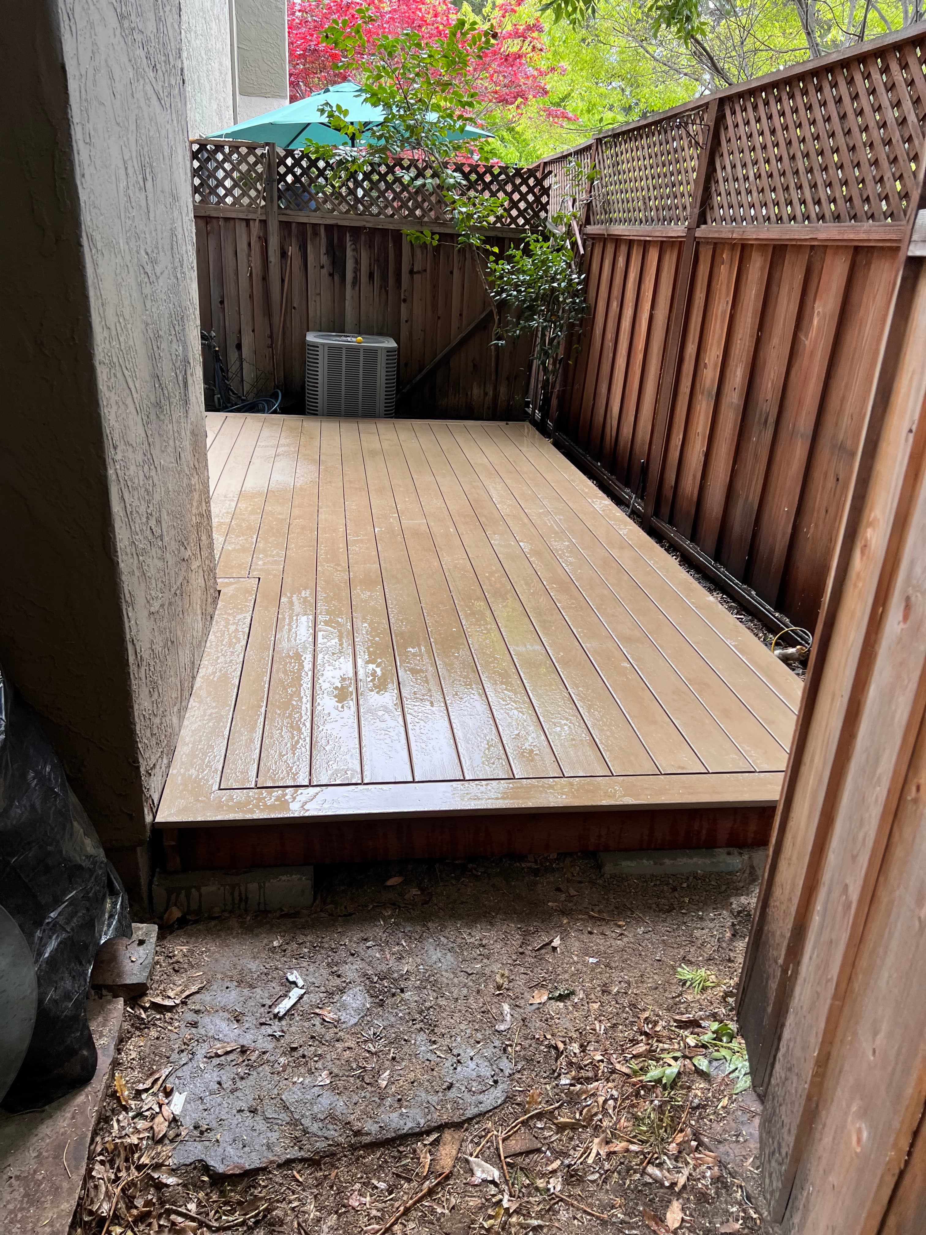 Composite deck boards installed under covered pergola by Far West Builders LLC